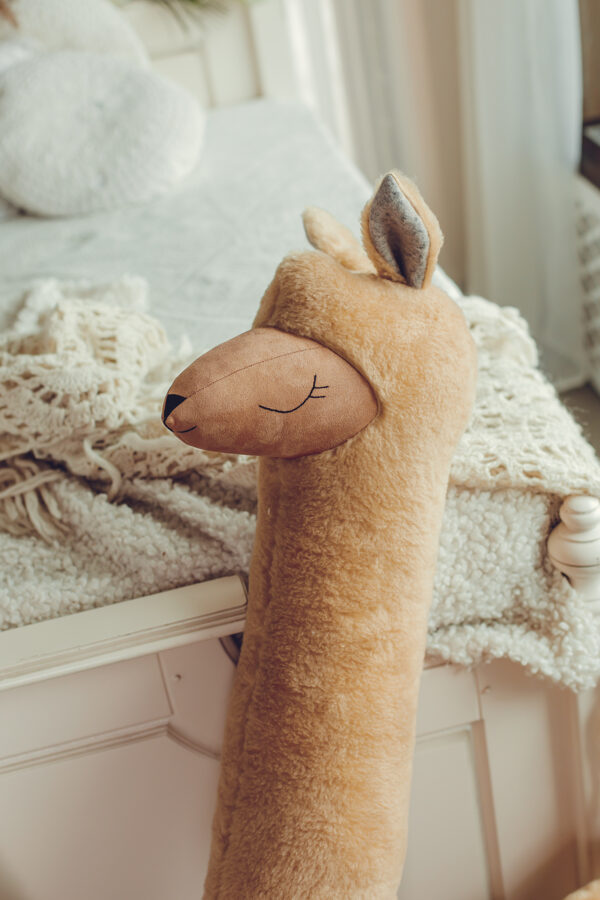 Grote alpaca knuffel roestbruin op bed