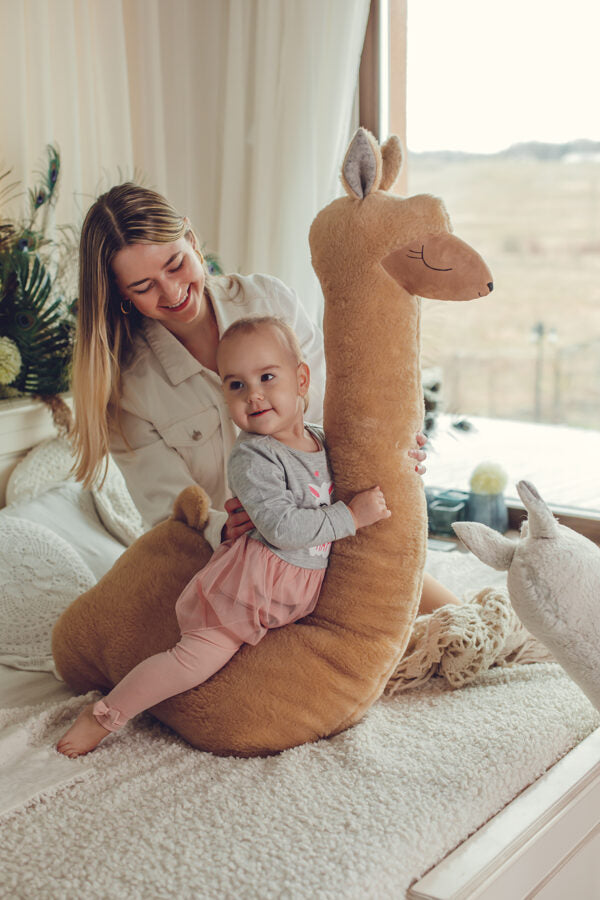 Grote alpaca knuffel roestbruin op bed – afbeelding 2