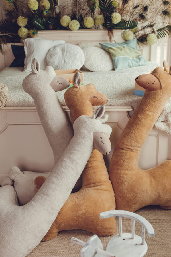 Grote alpaca knuffel roestbruin op bed – afbeelding 4