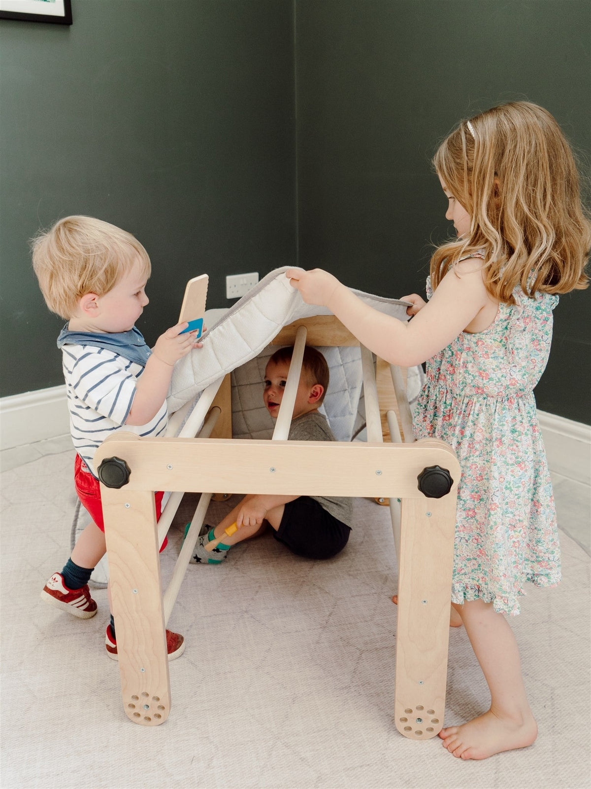 Kinderen spelen op een houten Pikler driehoek