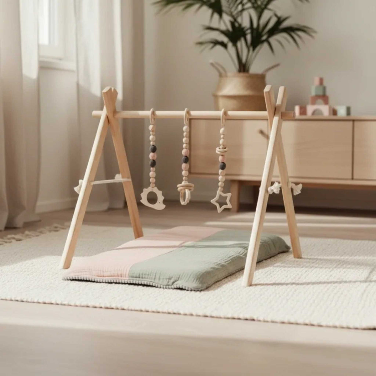Houten babygym met roze speeltjes – afbeelding 2
